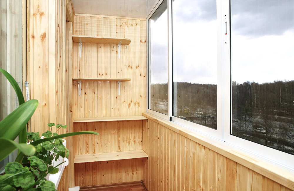 Холодное остекление балкона с отделкой деревом и местом для хранения